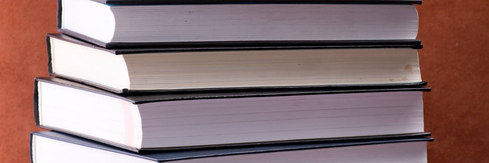 Stacked hardcover books on a deep red ground